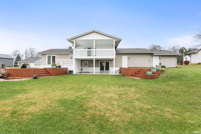 rear view of house featuring a lawn, a balcony, a patio, and a hot tub