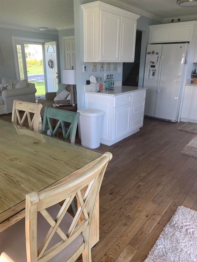 kitchen featuring tasteful backsplash, white cabinets, dark wood-type flooring, and white refrigerator with ice dispenser