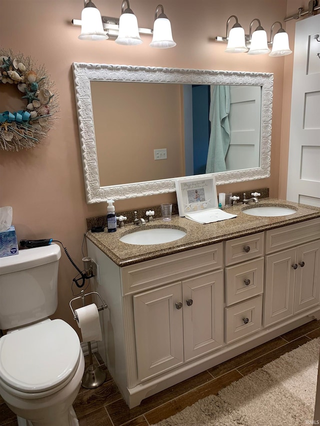 bathroom with hardwood / wood-style floors, vanity, and toilet