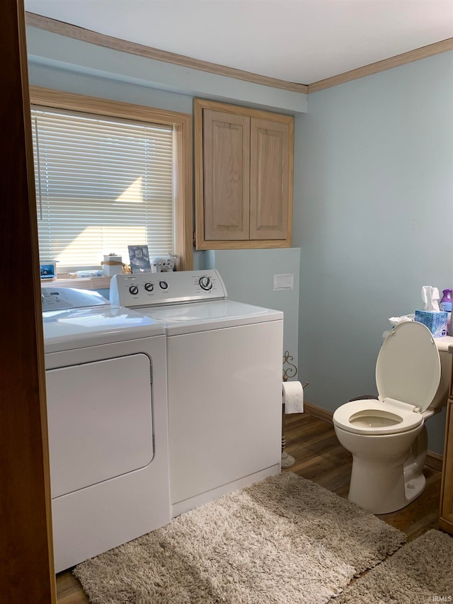 washroom featuring dark hardwood / wood-style flooring, crown molding, and washer and clothes dryer