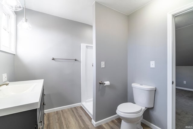 bathroom with a shower, hardwood / wood-style floors, vanity, and toilet