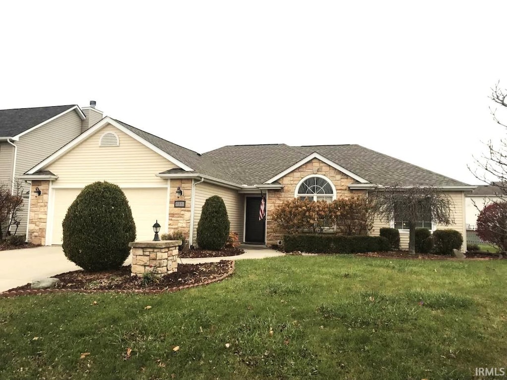 ranch-style home featuring a front lawn and a garage