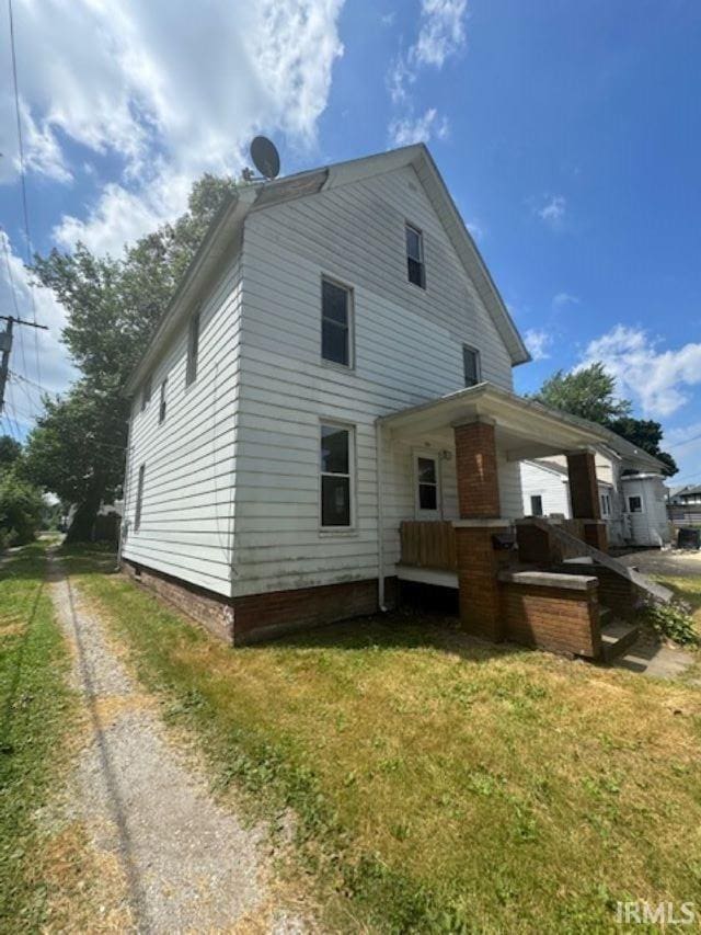 back of house featuring a lawn