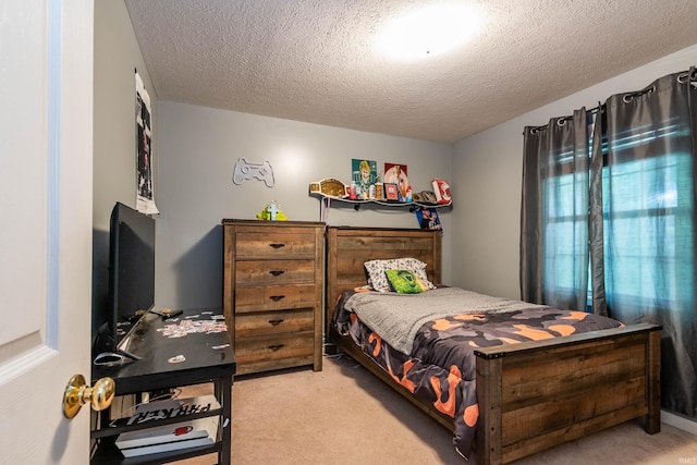 bedroom featuring light carpet and a textured ceiling