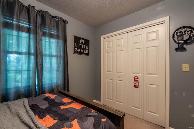 bedroom featuring a closet, carpet floors, and a textured ceiling