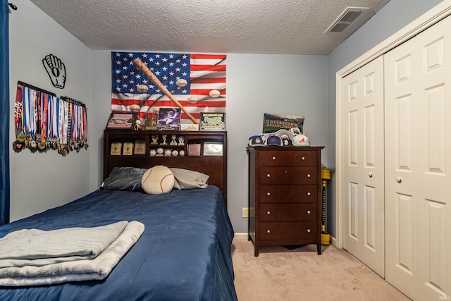 bedroom featuring carpet, a textured ceiling, and a closet