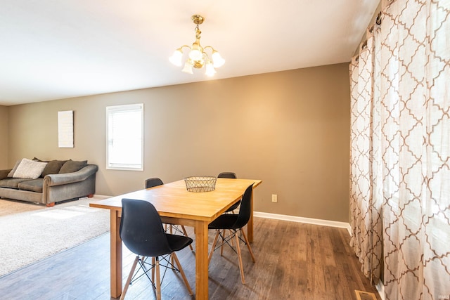 dining space with an inviting chandelier and dark wood-type flooring