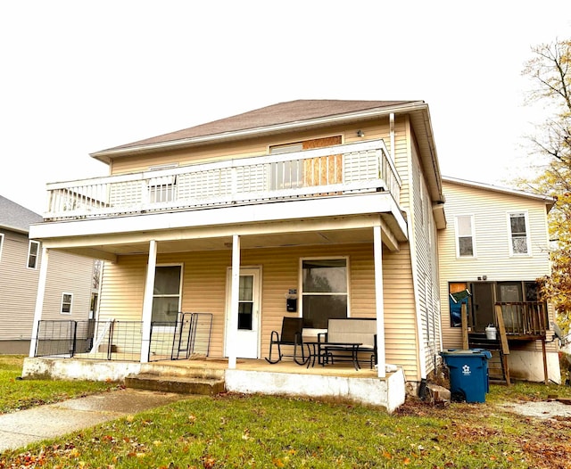 rear view of property with covered porch and a balcony