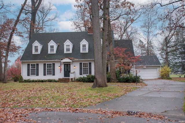 cape cod house featuring a garage and a front lawn