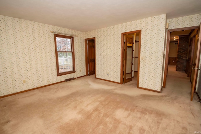 unfurnished bedroom with a spacious closet, light carpet, and a closet