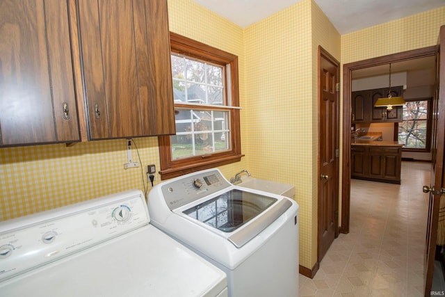 washroom with washer and dryer, cabinets, and sink