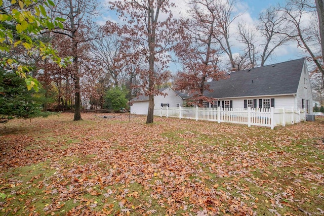 view of yard with central AC unit and a garage