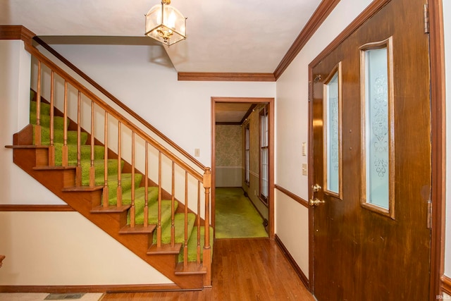 stairway with hardwood / wood-style floors and crown molding