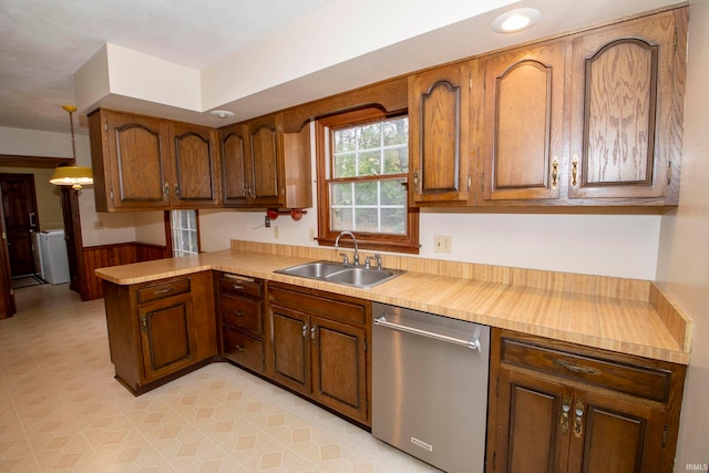 kitchen with dishwasher, sink, hanging light fixtures, washer / dryer, and kitchen peninsula