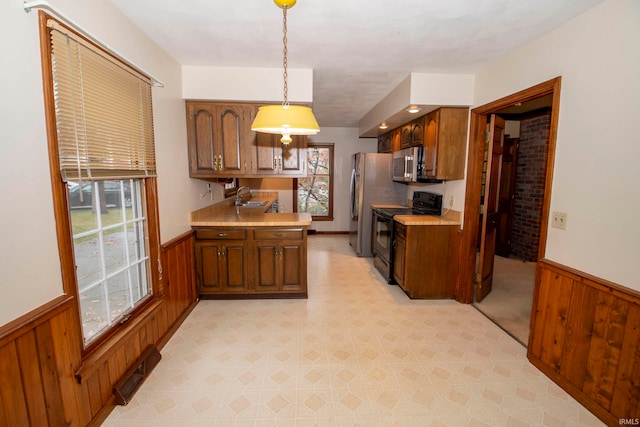 kitchen featuring pendant lighting, plenty of natural light, sink, and appliances with stainless steel finishes