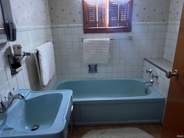 bathroom featuring sink, tile walls, and a washtub