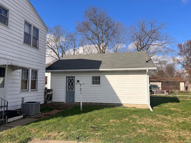 rear view of house with a lawn and central AC unit