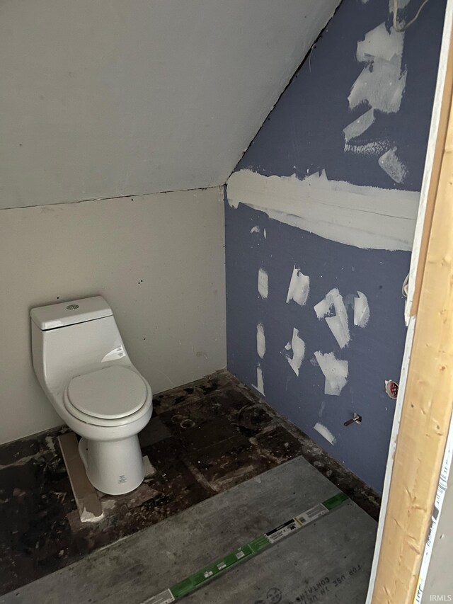 bathroom with lofted ceiling and toilet