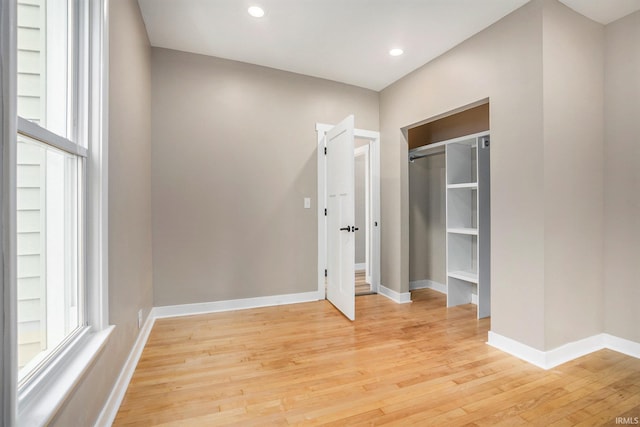 unfurnished bedroom with a closet and light hardwood / wood-style floors