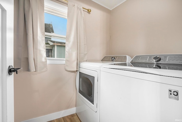 clothes washing area featuring independent washer and dryer, light hardwood / wood-style floors, and crown molding