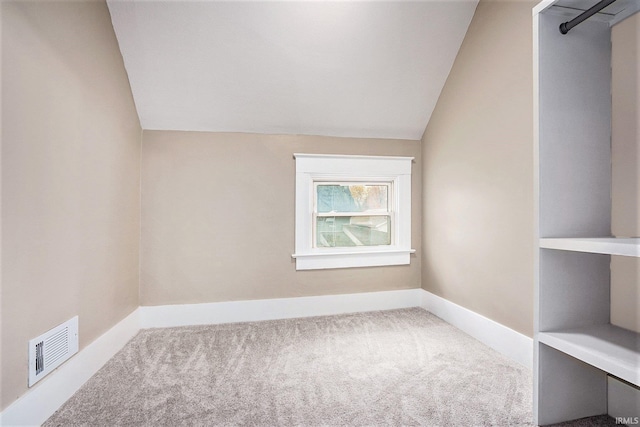 spare room featuring carpet floors and lofted ceiling