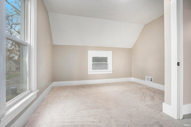 bonus room with carpet floors and vaulted ceiling