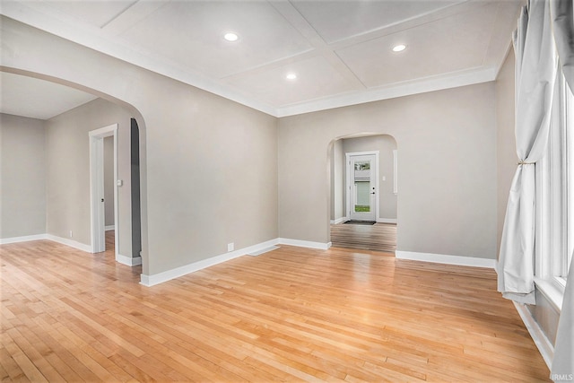 spare room with light hardwood / wood-style floors, a healthy amount of sunlight, ornamental molding, and coffered ceiling