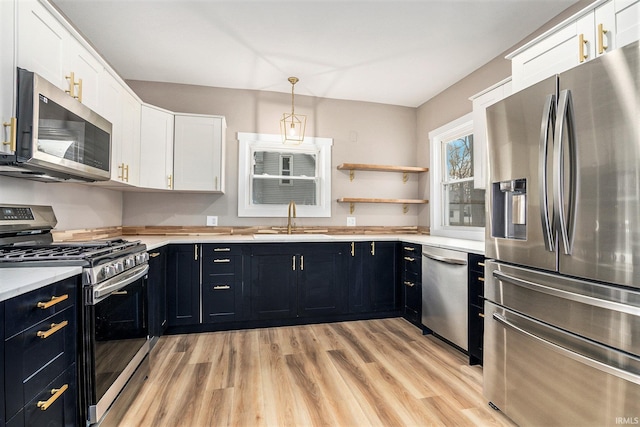 kitchen featuring sink, white cabinets, light wood-type flooring, and appliances with stainless steel finishes