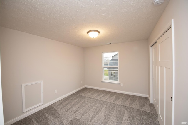 unfurnished bedroom featuring a closet, carpet, and a textured ceiling