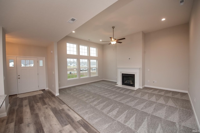 unfurnished living room featuring hardwood / wood-style flooring and ceiling fan