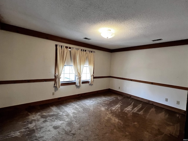 empty room with dark carpet and a textured ceiling