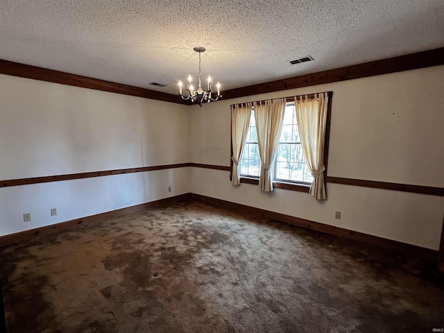 spare room with carpet flooring, a textured ceiling, and a notable chandelier