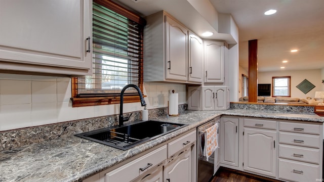 kitchen with white cabinetry, stainless steel dishwasher, a wealth of natural light, and sink