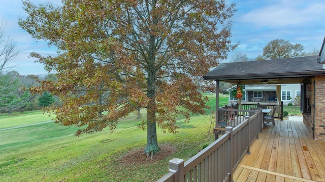 deck with a lawn and ceiling fan