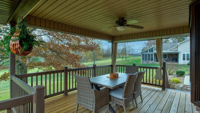 wooden terrace featuring a lawn and ceiling fan