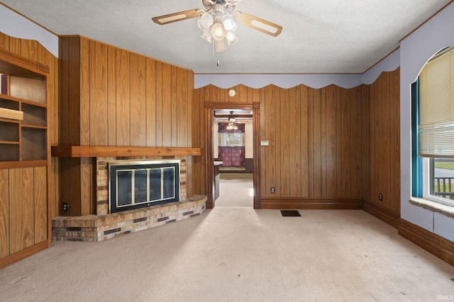 unfurnished living room with a fireplace, wood walls, and a textured ceiling