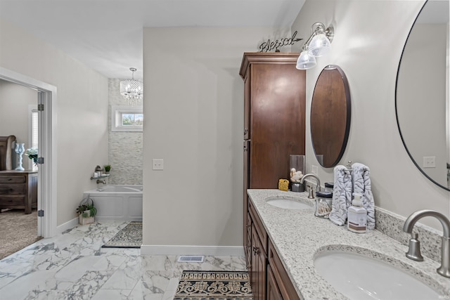 bathroom with a notable chandelier, a tub to relax in, and vanity