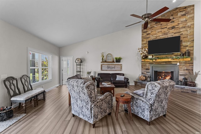 living room with a fireplace, hardwood / wood-style floors, high vaulted ceiling, and ceiling fan