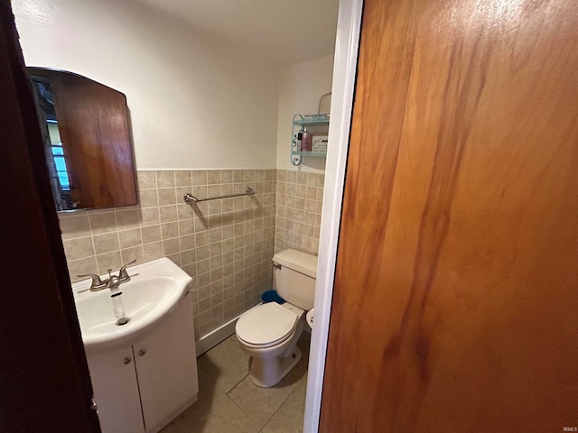 bathroom with tile patterned floors, vanity, toilet, and tile walls