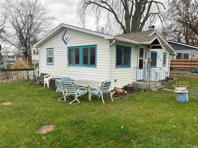 rear view of property with a lawn