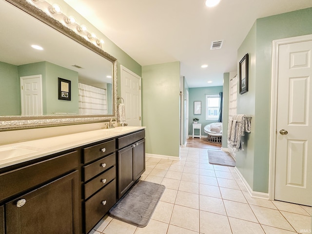 bathroom with double vanity, tile patterned flooring, visible vents, and a sink