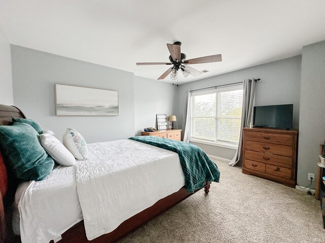 bedroom featuring ceiling fan, baseboards, and light colored carpet