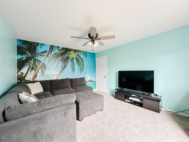 carpeted living area with ceiling fan and baseboards