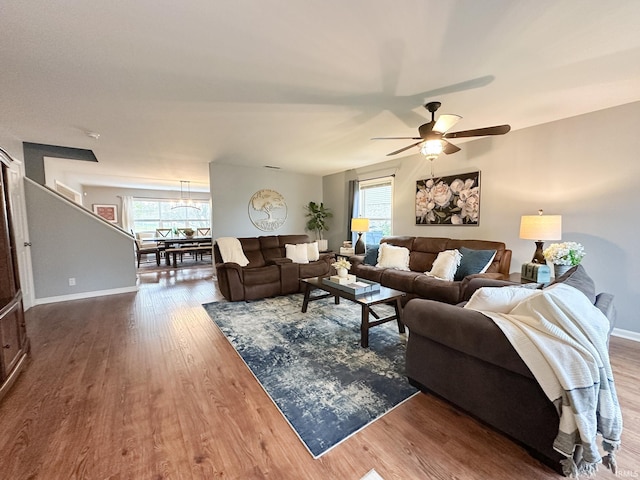 living room featuring ceiling fan and dark wood-type flooring