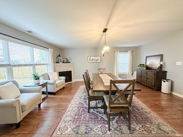 dining room with a fireplace, wood finished floors, and baseboards