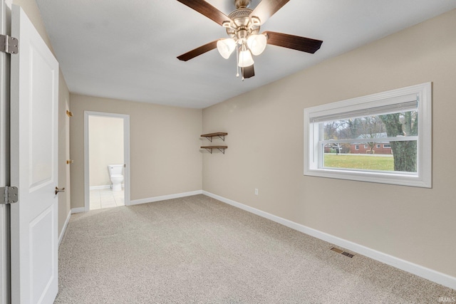 empty room featuring ceiling fan and light colored carpet