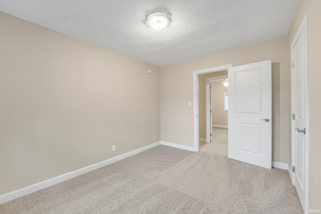 carpeted empty room with a textured ceiling