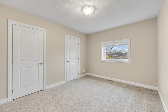 unfurnished bedroom with carpet floors and a textured ceiling