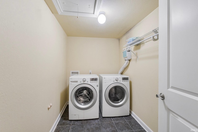 laundry room featuring washer and dryer and dark tile patterned flooring