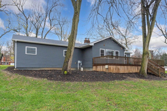 rear view of property featuring a lawn and a wooden deck